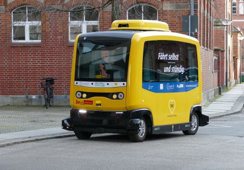 Ein kleiner gelber Bus der Berliner Verkehrsbetriebe, der autonom fährt.