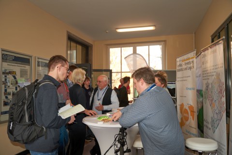 Menschen im Gespräch an einem Messestand