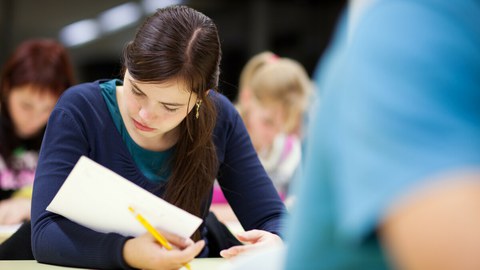 Das Bild zeigt konzentrierte Studierende in einem Examen