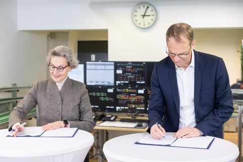 Eine Frau und ein Mann unterschreiben Urkunden in einem Labor