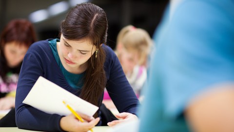 Das Bild zeigt eine Studentin beim Lesen