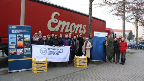 Studentengruppe mit den zu verladenden Stollen vor dem Container