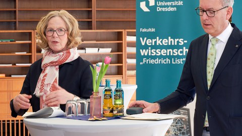Staatsministerin Kraushaar vor einem Banner der Fakultät