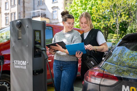 Studentinnen an einer E-Ladesäule