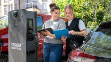 Studentinnen an einer E-Ladesäule