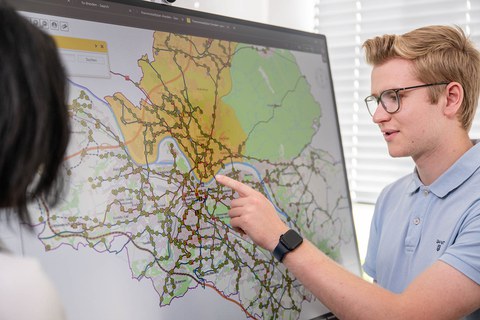 Studierende vor einem Verkehrsplan