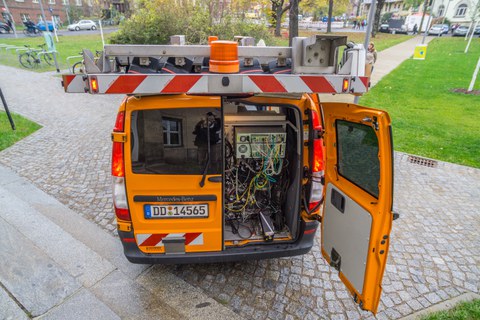Measurement vehicle for recording the road space using front and rear cameras with path-dependent or time-dependent image triggering