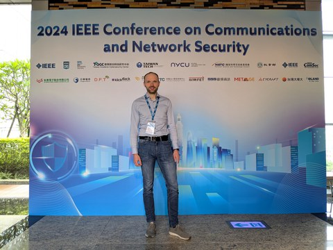 Person vor der Werbetafel zur IEEE CNS 2024 in Taipei