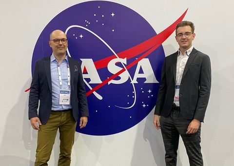 Lars Hornuf und Daniel Vrankar vor einem Logo der NASA