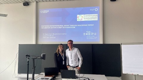 Moderators in front of a whiteboard and PowerPoint presentation