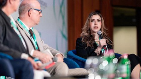 Female speaker holding a microphone during the discussion