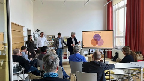 Teilnehmende des Forschungskolloquiums schauen gespannt auf Vortragenden