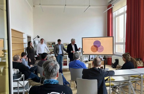 Participants in the research colloquium listen intently to the speaker