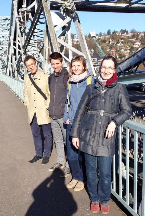 4 Personen stehen auf einer Brücke.