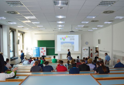 Hörsaal mit mehreren Personen in den Stuhlreihen. 