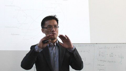 A man with glasses gives a presentation. 