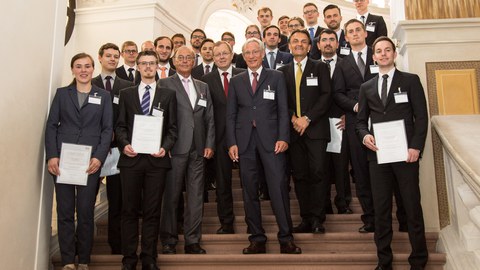 Group picture on a staircase. Some people hold certificates in their hands.