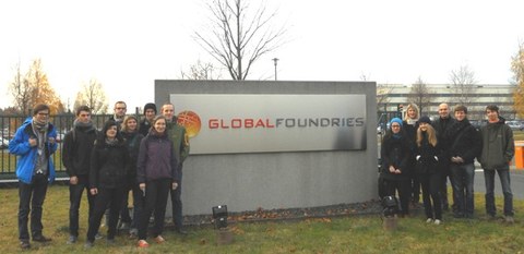 Gruppenbild vor dem Werktor. In der Mitte eine Tafel mit der Aufschrift Global Foundries.