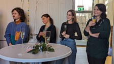 Es sind vier Menschen bei einer Feier zu sehen.
