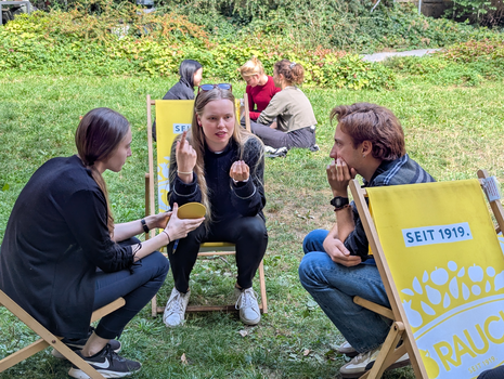 Zu sehen sind junge Menschen auf einer Wiese bei einem Workshop