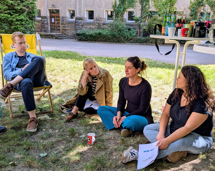 Zu sehen sind junge Menschen auf einer Wiese bei einem Workshop