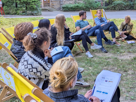 Zu sehen sind die Teilnehmer eines Workshops auf einer Wiese