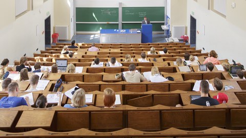 Foto von einem Hörsaal, in dem gerade eine Vorlesung stattfindet.