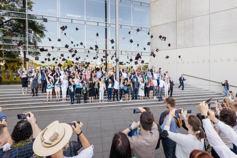 Die Absolventen werfen ihre Hüte 