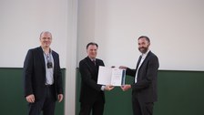 Es sind Prof. Wiener, Prof. Krancher und der Dekan bei einer Preisverleihung zu sehen