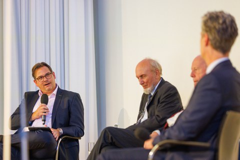 Zu sehen ist Prof. Leßmann bei der Moderation einer Podiumsdiskussion