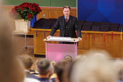 Es ist der Dekan zu sehen, der ein Grußwort hält