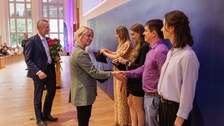 Es sind Professoren zu sehen, die Absolventen zum Abschluss des Studiums gratulieren