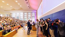 Es sind Professoren zu sehen, die Absolventen zum Abschluss des Studiums gratulieren