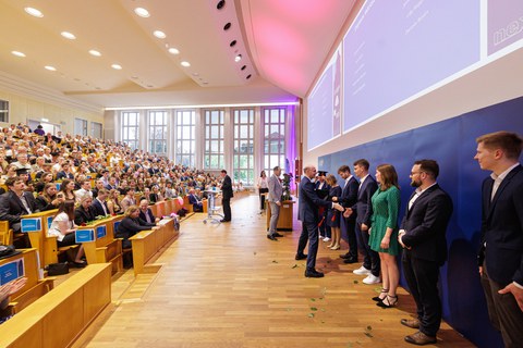 Es sind Professoren zu sehen, die Absolventen zum Abschluss des Studiums gratulieren