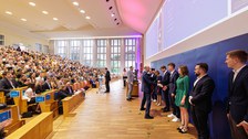 Es sind Professoren zu sehen, die Absolventen zum Abschluss des Studiums gratulieren