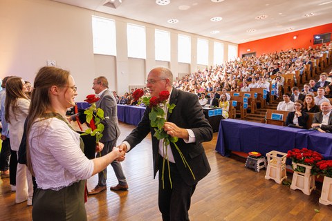 Zu sehen ist Prof. Siems bei der Rosenübergabe