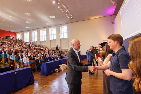 Zu sehen ist Prof. Thum bei der Rosenübergabe