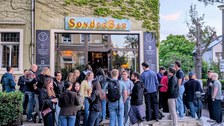 Zu sehen ist eine große Gruppe junger Menschen vor der SonderBar