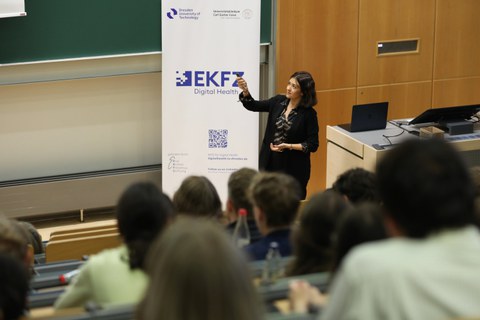 Zu sehen ist eine Dozentin, die einen Vortrag hält
