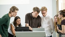 Zu sehen ist eine Gruppe Studierender an einem Laptop