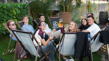 Zu sehen sind junge Menschen die in Liegestühlen sitzen