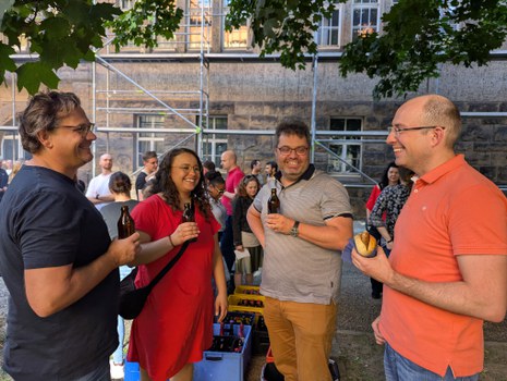 Zu sehen sind vier junge Menschen bei einem Grillfest