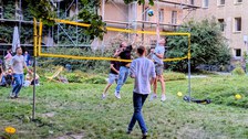 Zu sehen sind junge Menschen, die Volleyball spielen