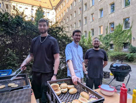 Zu sehen sind drei Männer am Grill
