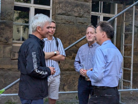 Es ist eine Gruppe Menschen zu sehen, die sich unterhalten