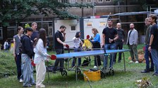 Es sind Menschen bei einem Fest zu sehen, die Tischtennis spielen
