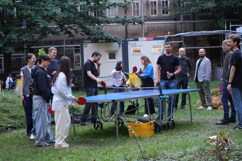 Es sind Menschen bei einem Fest zu sehen, die Tischtennis spielen