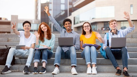 Man sieht viele freudige Studierende