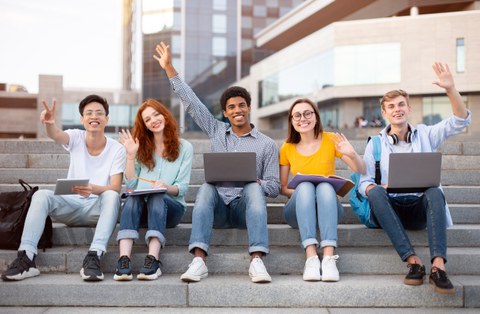 Man sieht viele freudige Studierende