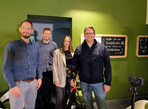 Zu sehen sind Dr. Philipp Richter, Tobias Hatzfeld, Prof. Christian Leßmann und Katharina Bettig bei einem Videodreh in der coffeebar "Ins Grüne" 